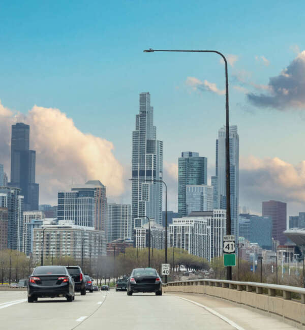 Chicago Illinois, USA. Cars on the ring road driving to Chicago city downtown, high rise buildings and cloudy sky background